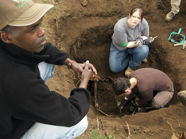 UIndy grad student Amandine Eriksen, upper rights, works with anthropologist Shannon C. McFarlin of The George Washington University and veterinarian Antoine Mudakikwa of the Rwandan Office of Tourism and National Parks to excavate a mountain gorilla skeleton.