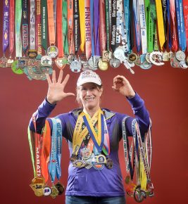 Dr. Kathy Stickney (Chemistry Department) has successfully completed marathons in all 50 states. She's received various medals from the runs which she gathered for this environmental portrait on January 11, 2017. (Photo by D. Todd Moore, University of Indianapolis)