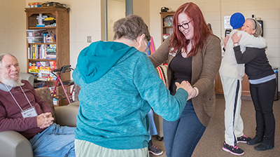 Student Tori Zimmerman dances during a therapy session. Prof. Jan Schreibman is on the right. At Still Waters Adult Day Care facility in Indianapolis.