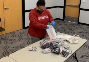 A student assembles care packages for a service project to support the University Heights neighborhood during the coronavirus pandemic.