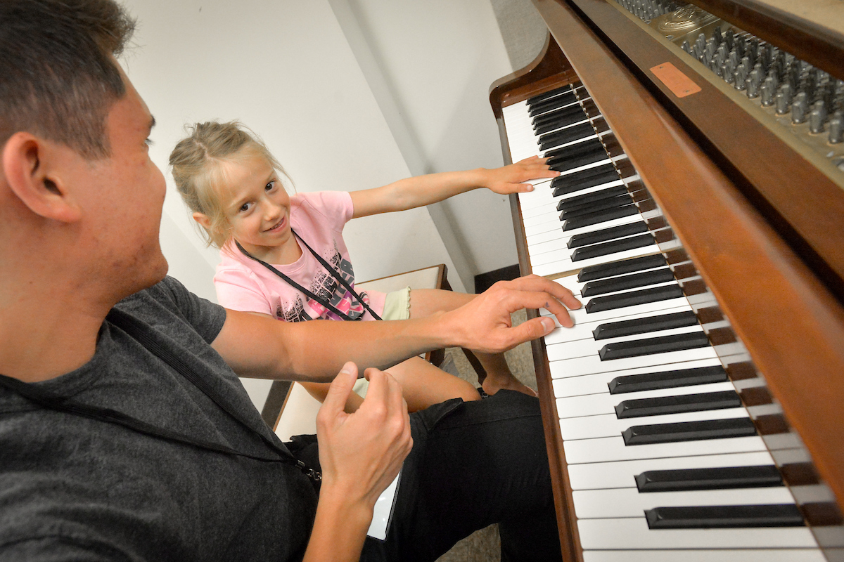 youth with instructor at the piano