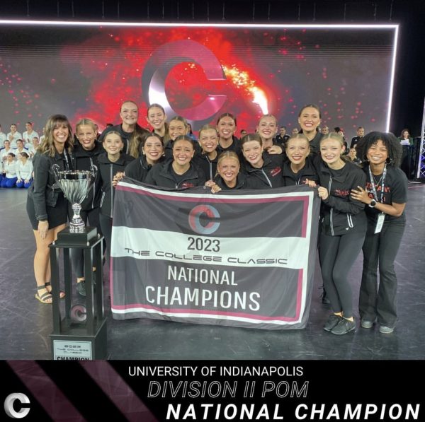 uindy dance team poses as national champions, holding up sign "2023 national champions"