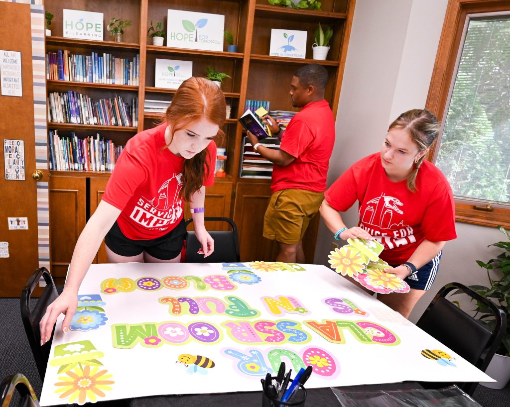 Photo of two UIndy students constructing a poster at Hope for Tomorrow