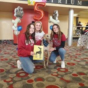 Photo of Grady the Greyhound with a group of UIndy students at his fifth birthday party