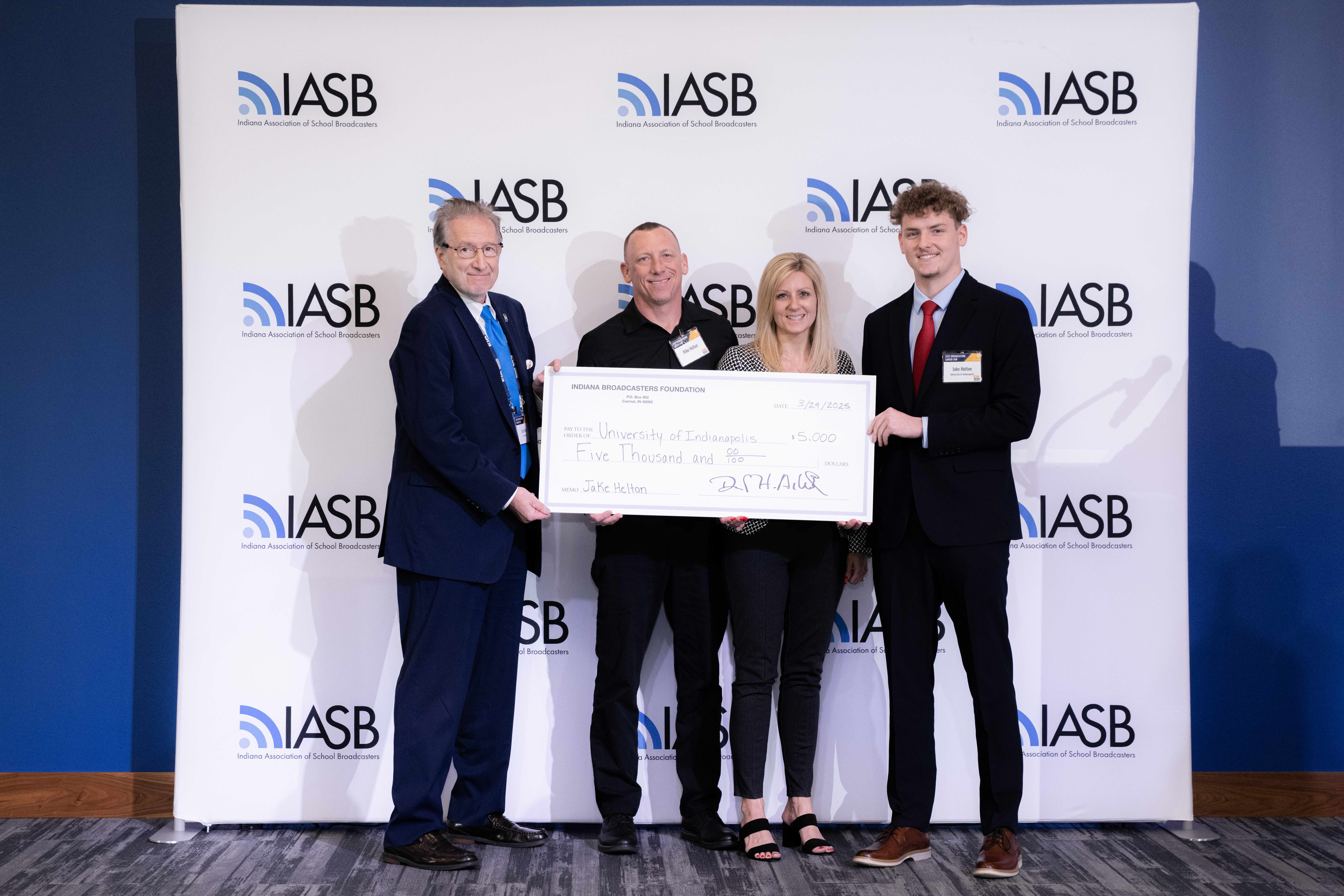 Photo of Jake Helton and his family with an IBA representative with his scholarship check
