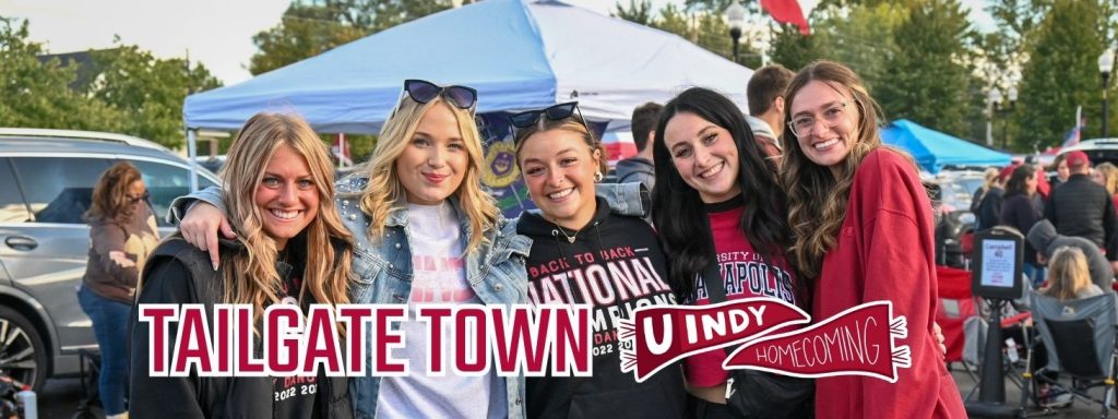 Tailgate Town, UIndy Homecoming. Group of women pose for a photo wearing UIndy gear.