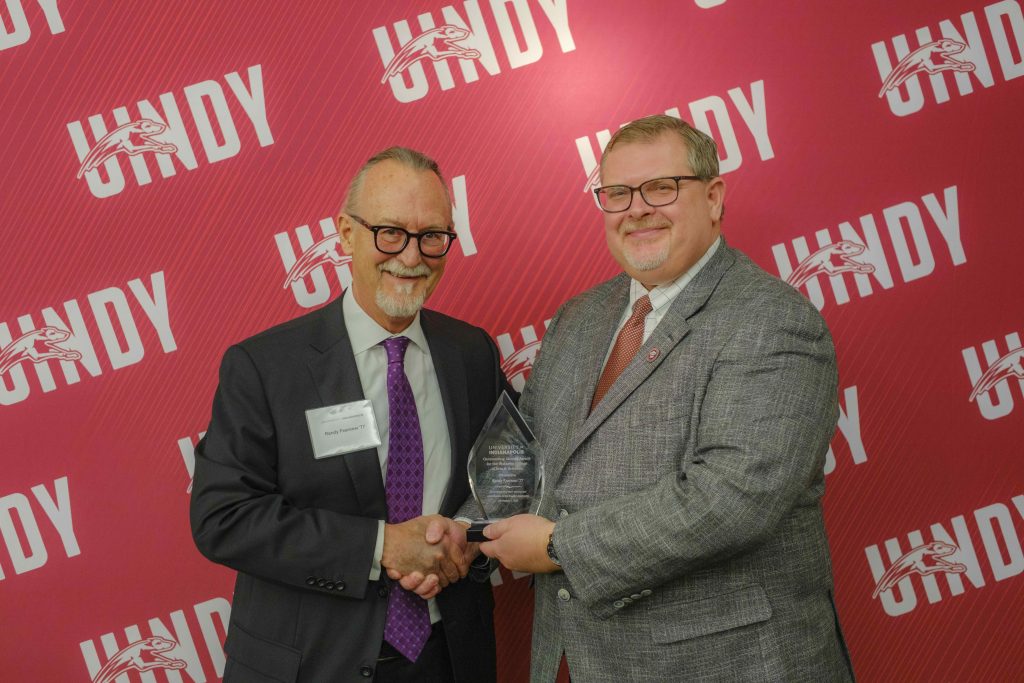 Photo of Randy Fearnow receiving an outstanding alumni award from Dr. Travis Miller