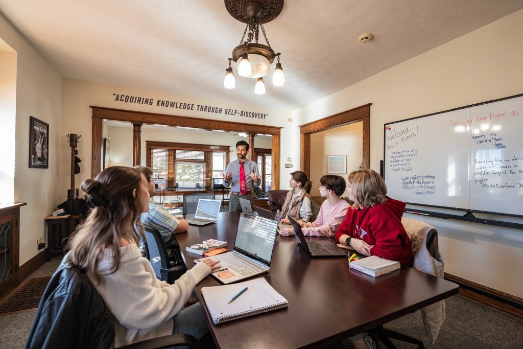 Photo of a UIndy professor instructing Honors students in the Honors House conference room