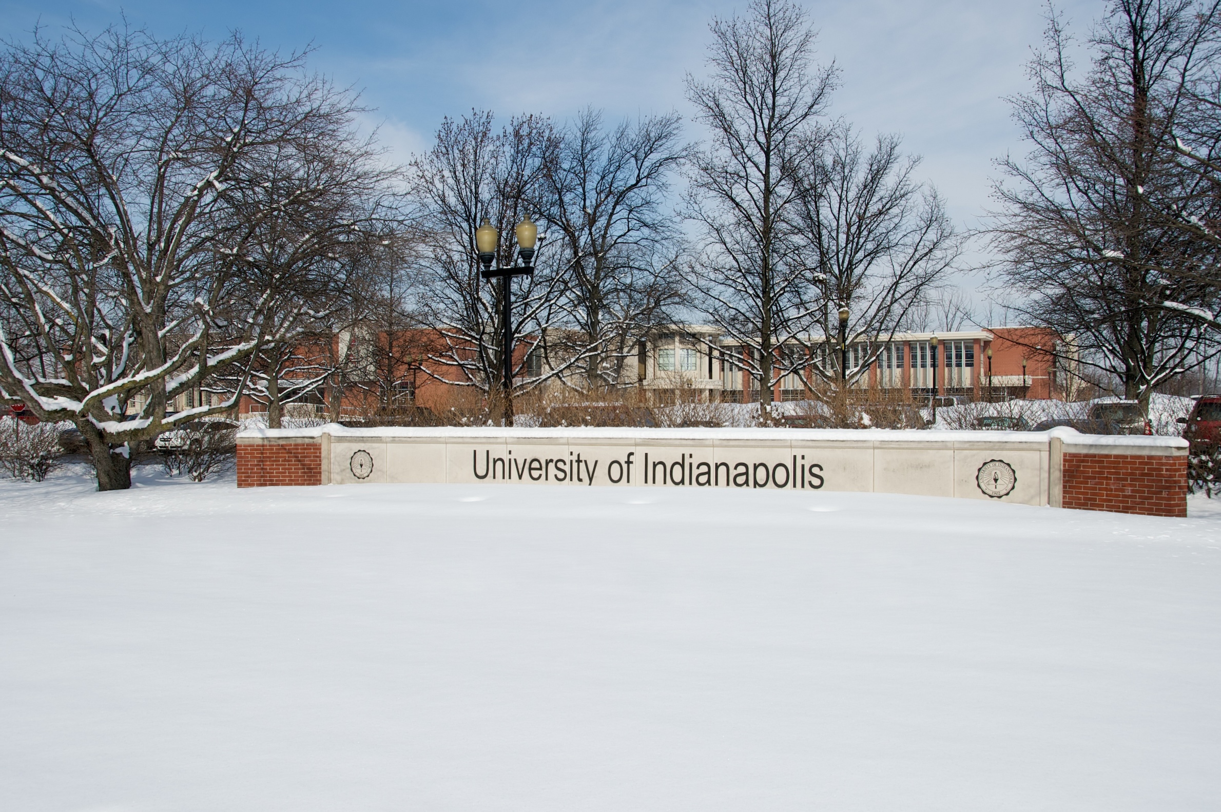 UIndy campus sign with snow in winter