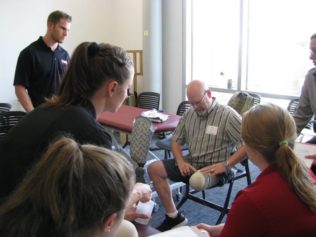 A community patient resource group volunteer speaks with UIndy students