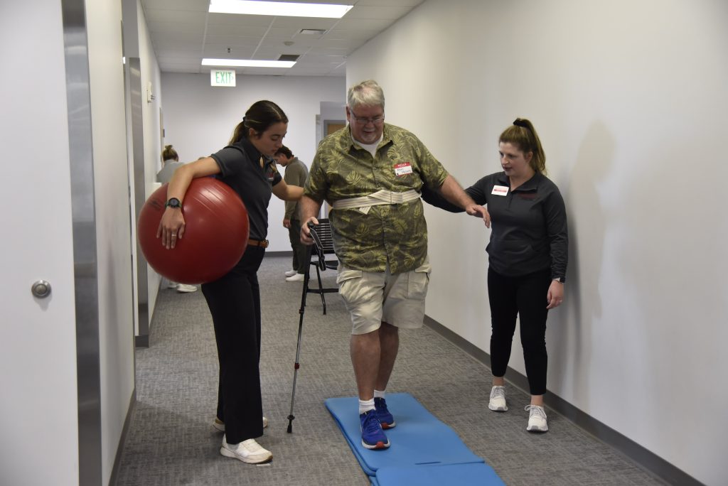 A community patient resource group volunteer does a walking exercise with UIndy students