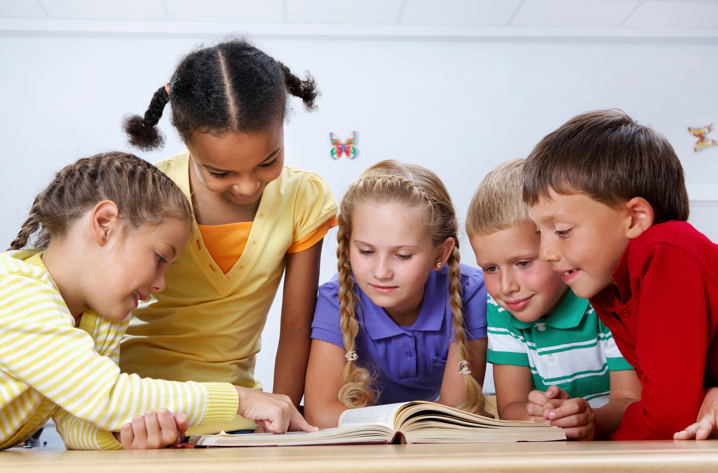 Children reading a book together.