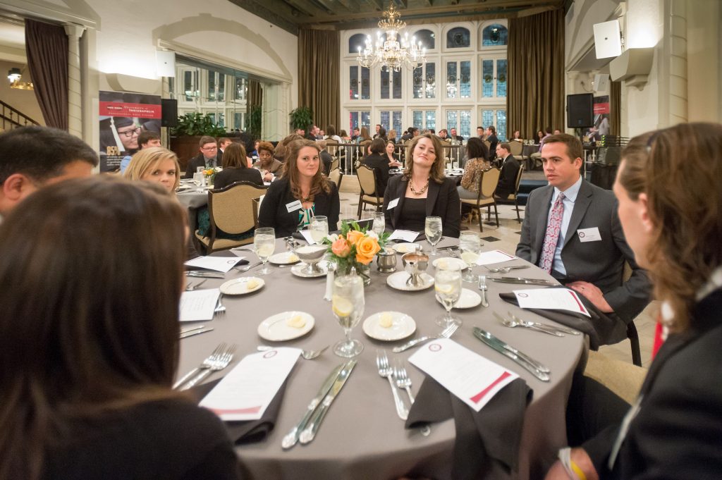 Professionally dressed professionally sit at fancy dinner table
