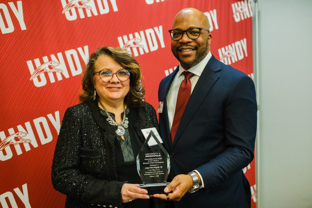 Dr. John Kuykendall presents Sonya Ware-Meguiar with her Outstanding Alumni Award