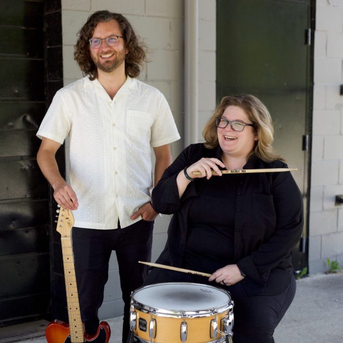 Photo of Chelsea Hughey with drum and Charles Platz with guitar