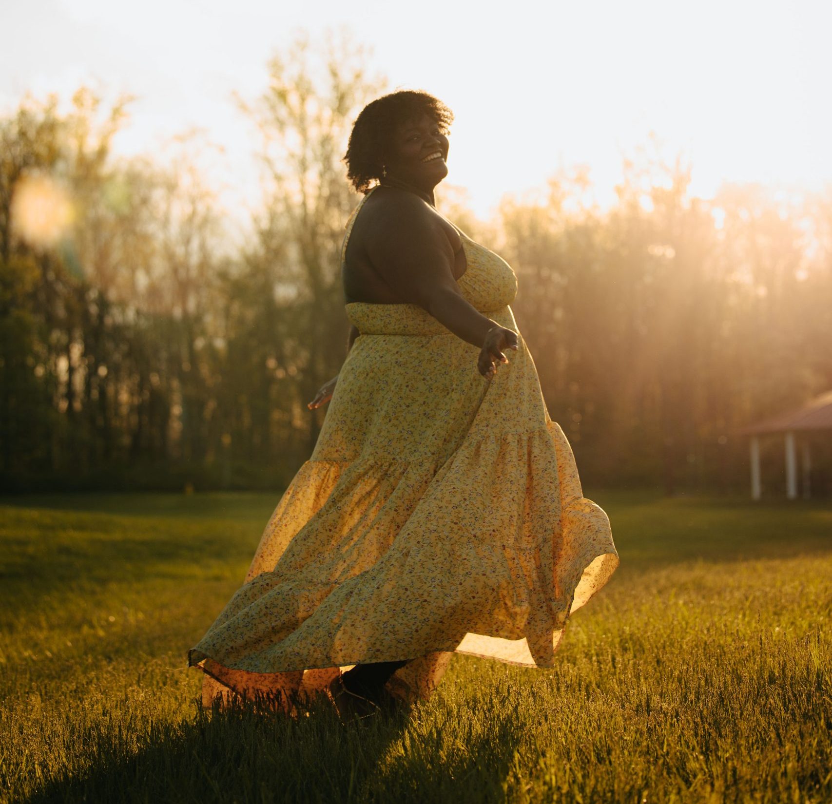 Anouka Metangmo wears a dress with sunset in background